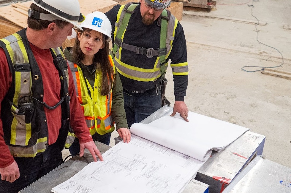 3 engineers looking at a technical drawing