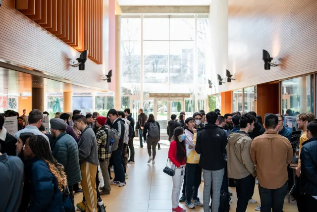 A busy hallway filled with people attending a fair.