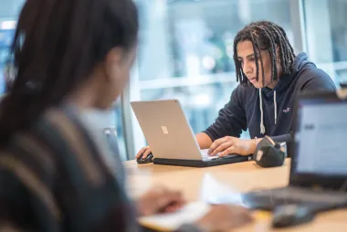 a guy looking over his laptop.