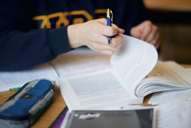 a student flipping a page of the textbook.