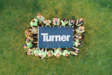 Turner Construction staff holding a Turner sign 