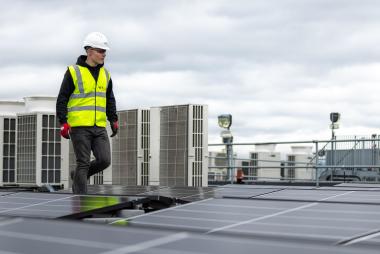 An Engineer walking near solar panels. 