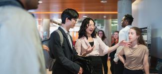 Three students listening to a student speaking.