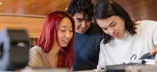 Three students collaborating on a project.