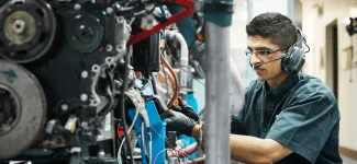 A student fixing a machine
